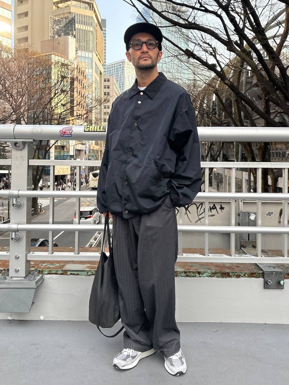 グレー系のスラックス、ホワイト系のTシャツ/カットソーを着用したメンズの春コーディネートの2枚目の写真
