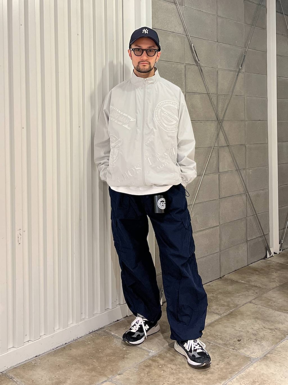 ホワイト系のTシャツ/カットソー、ブルー系のカーゴパンツ、グレー系のブルゾンを着用したメンズの春コーディネートの5枚目の写真