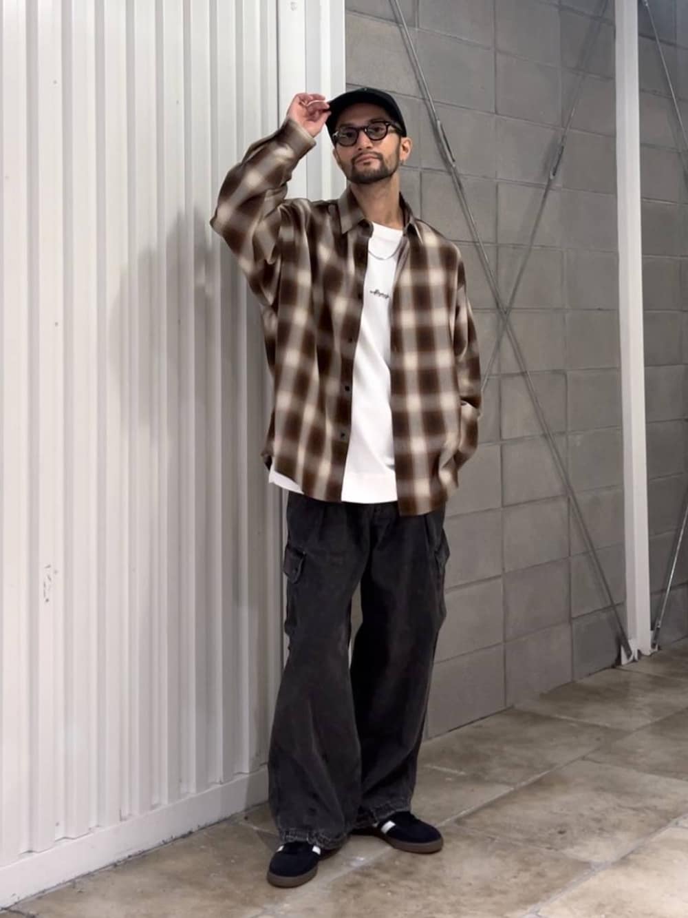 ブラック系のスニーカー、グレー系のデニムパンツ、ホワイト系のTシャツ/カットソーを着用したメンズの秋コーディネートの2枚目の写真