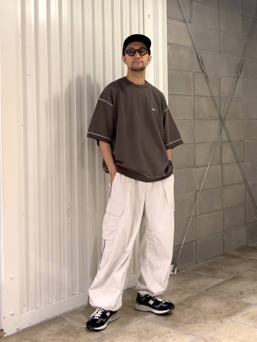 ブラック系のTシャツ/カットソー、ホワイト系のカーゴパンツを着用したメンズの夏コーディネートの5枚目の写真