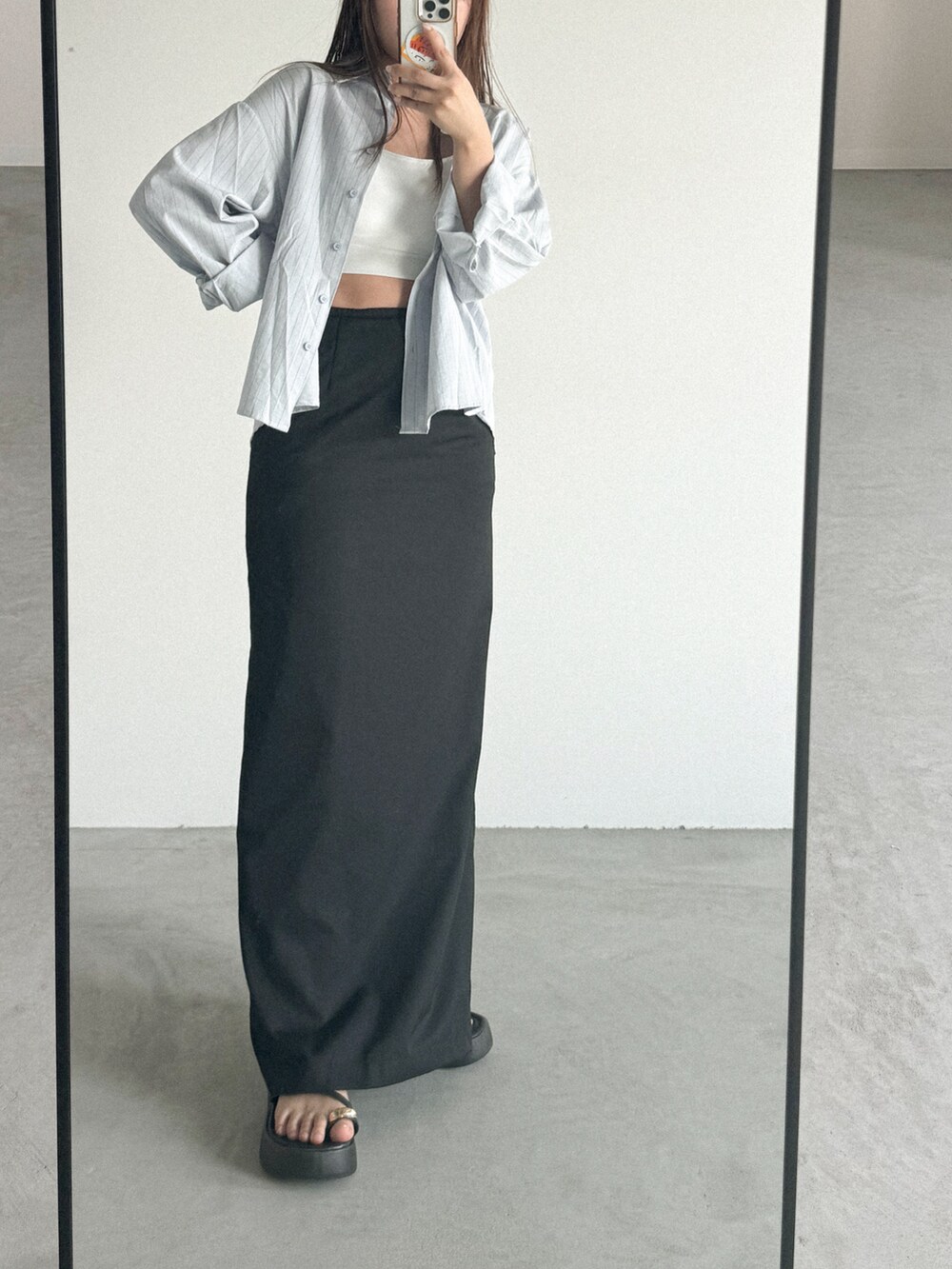 ブラック系のスカート、ホワイト系のチューブトップを着用したレディースの春コーディネートの2枚目の写真