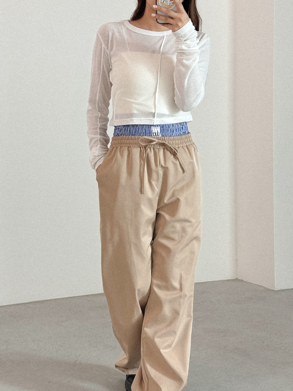 ホワイト系のTシャツ/カットソー、ベージュ系のスラックスを着用したレディースの春コーディネートの2枚目の写真