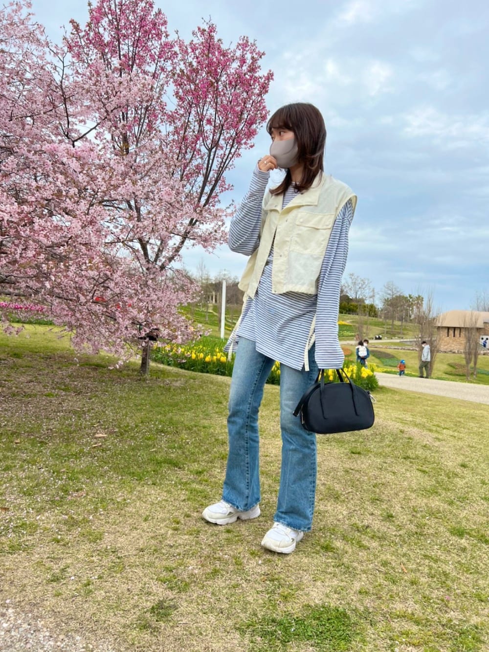 ホワイト系のジャケット/アウター、ブルー系のトップス、ブルー系のデニムパンツを着用したレディースの春コーディネートの2枚目の写真