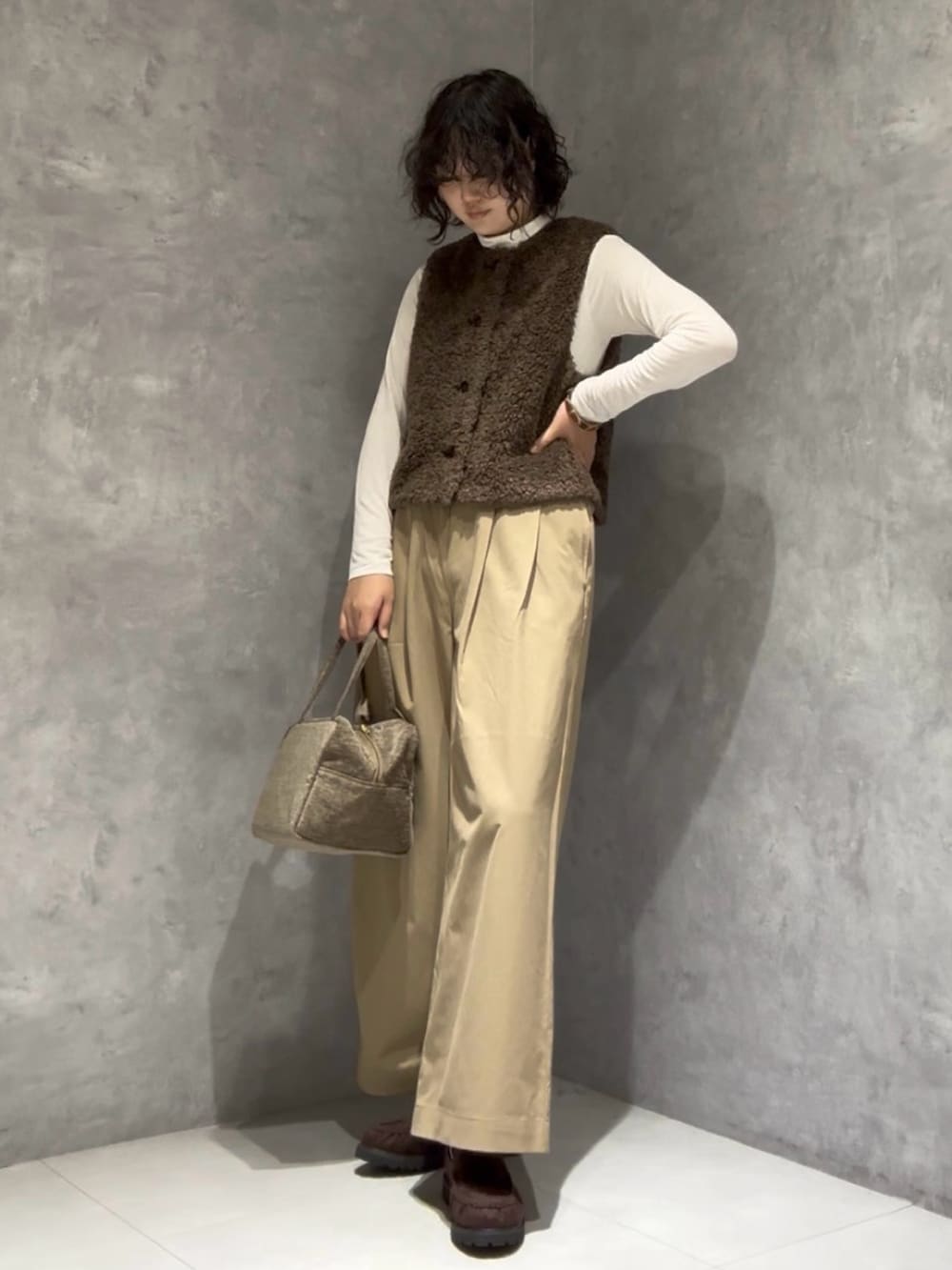 ベージュ系のその他パンツ、ブラウン系のローファー、グリーン系のハンドバッグを着用したレディースの秋コーディネートの3枚目の写真
