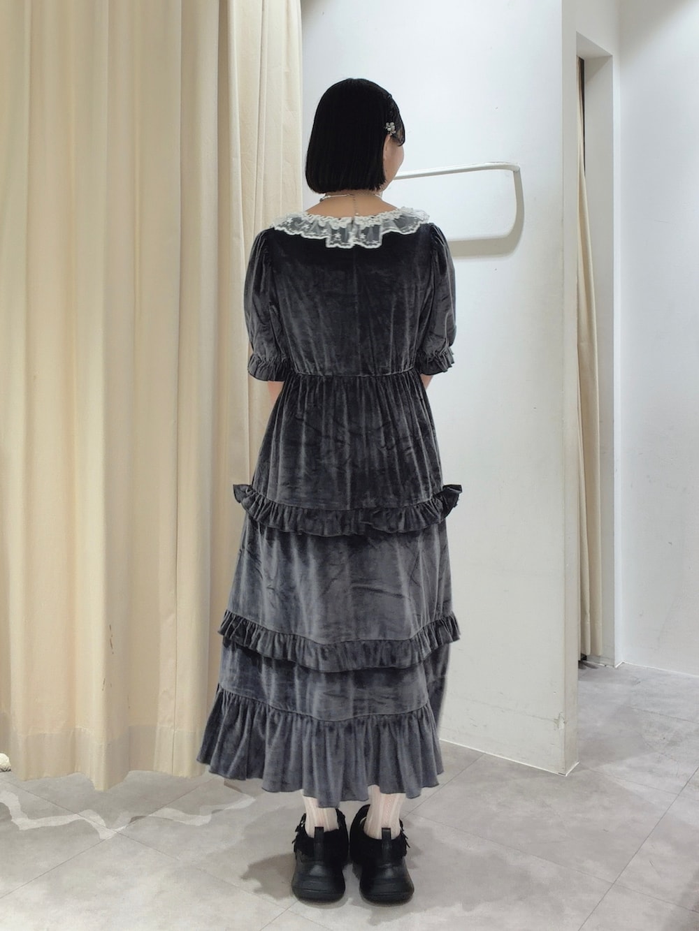 グレー系のワンピース、ブラウン系のハンドバッグ、ブラック系のスニーカーを着用したレディースの夏コーディネートの4枚目の写真