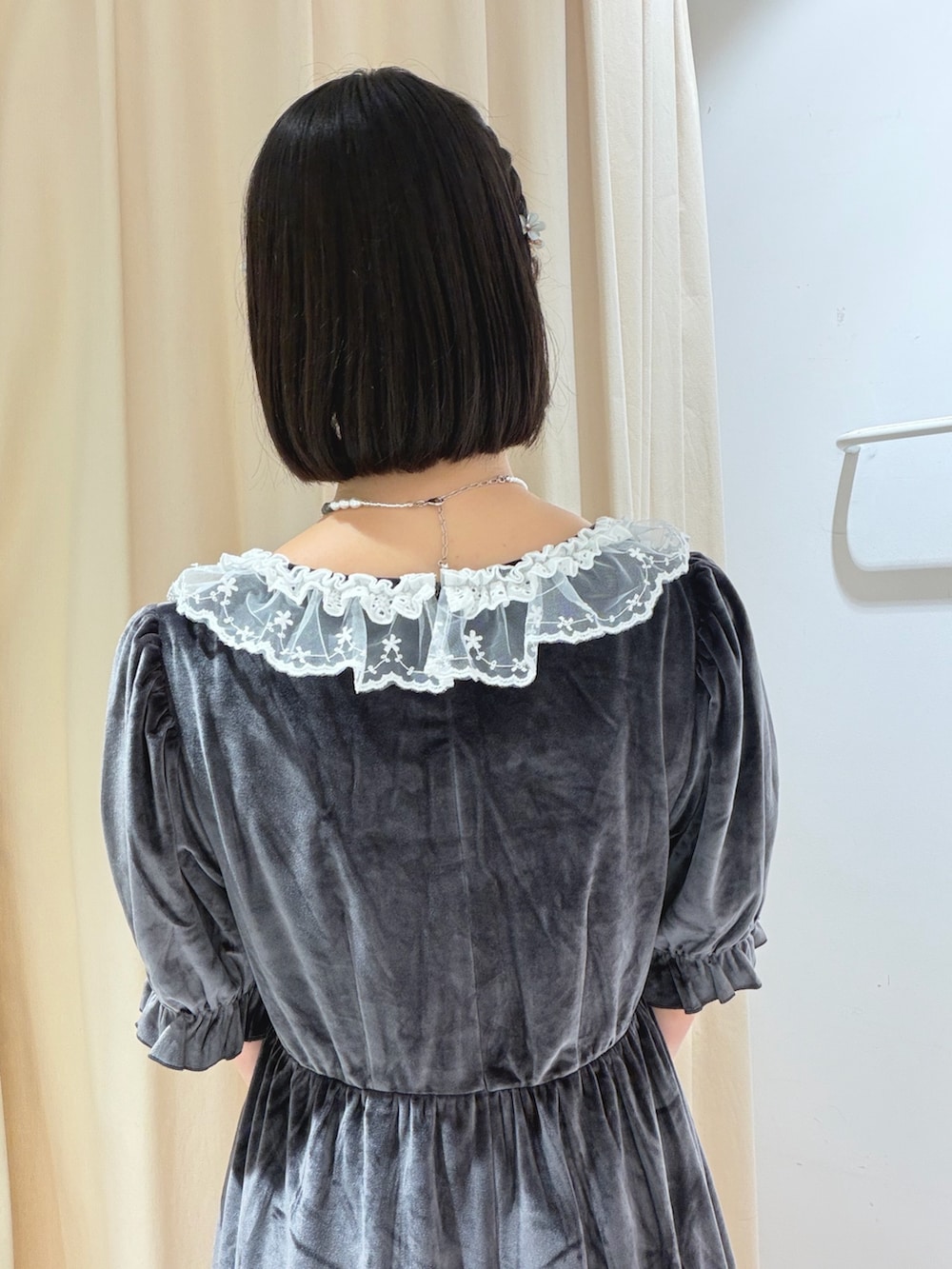 グレー系のワンピース、ブラウン系のハンドバッグ、ブラック系のスニーカーを着用したレディースの夏コーディネートの7枚目の写真