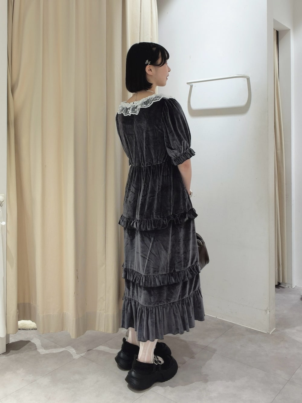 グレー系のワンピース、ブラウン系のハンドバッグ、ブラック系のスニーカーを着用したレディースの夏コーディネートの5枚目の写真