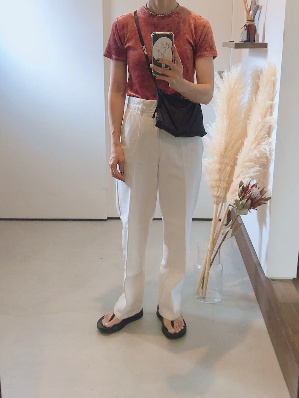 ピンク系のTシャツ/カットソー、ホワイト系のデニムパンツ、ブラック系のショルダーバッグを着用したレディースの夏コーディネートの2枚目の写真
