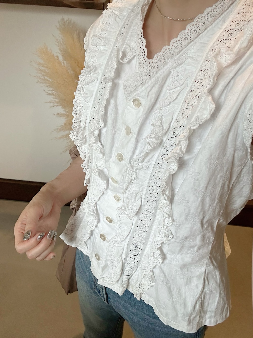 ブルー系のデニムパンツ、ブラウン系のエコバッグ/サブバッグ、ブラック系のサンダルを着用したレディースの夏コーディネートの3枚目の写真