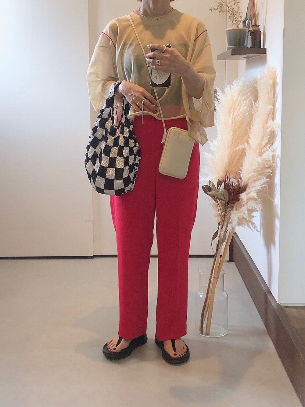 ベージュ系のニット/セーター、ピンク系のその他パンツ、ブラック系のエコバッグ/サブバッグを着用したレディースの夏コーディネートの2枚目の写真