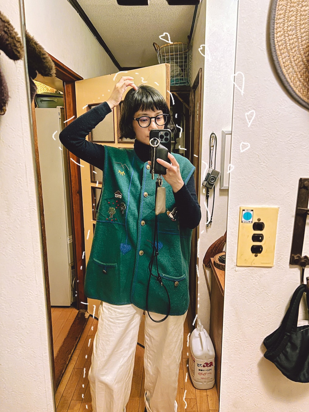 グリーン系のベスト、ブラック系のニット/セーター、ブラック系のメガネを着用したレディースの春コーディネートの2枚目の写真