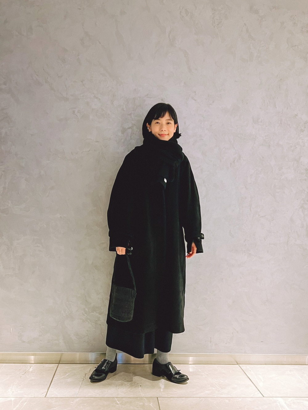 ブラック系のジャケット/アウター、ブラック系のかごバッグ、ブラック系のドレスシューズを着用したレディースの冬コーディネートの2枚目の写真