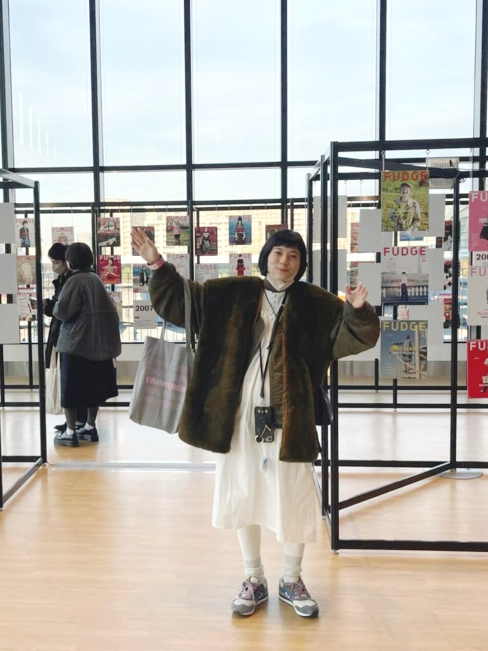 グリーン系のその他アウター、ホワイト系のシャツワンピース、グレー系のスニーカーを着用したレディースの春コーディネートの2枚目の写真