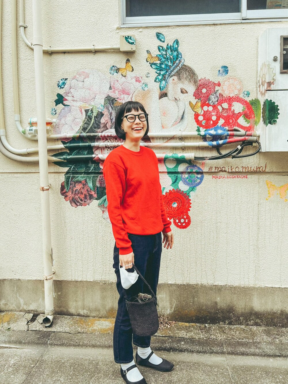 ブルー系のデニムパンツ、ブラック系のバレエシューズ、レッド系のスウェットを着用したレディースの春コーディネートの2枚目の写真