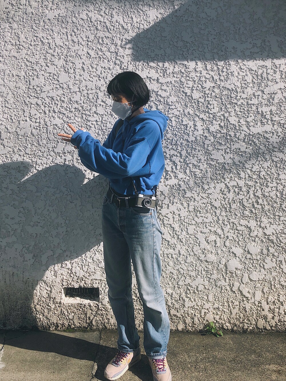 ブルー系のパーカー、ブルー系のデニムパンツ、ブラック系のショルダーバッグを着用したレディースの冬コーディネートの3枚目の写真