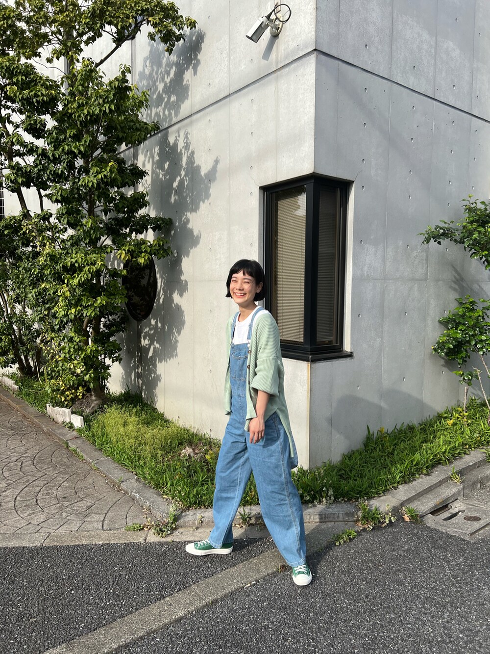 グリーン系のカーディガン/ボレロ、ブルー系のサロペット/オーバーオール、ブルー系のかごバッグを着用したレディースの春コーディネートの3枚目の写真