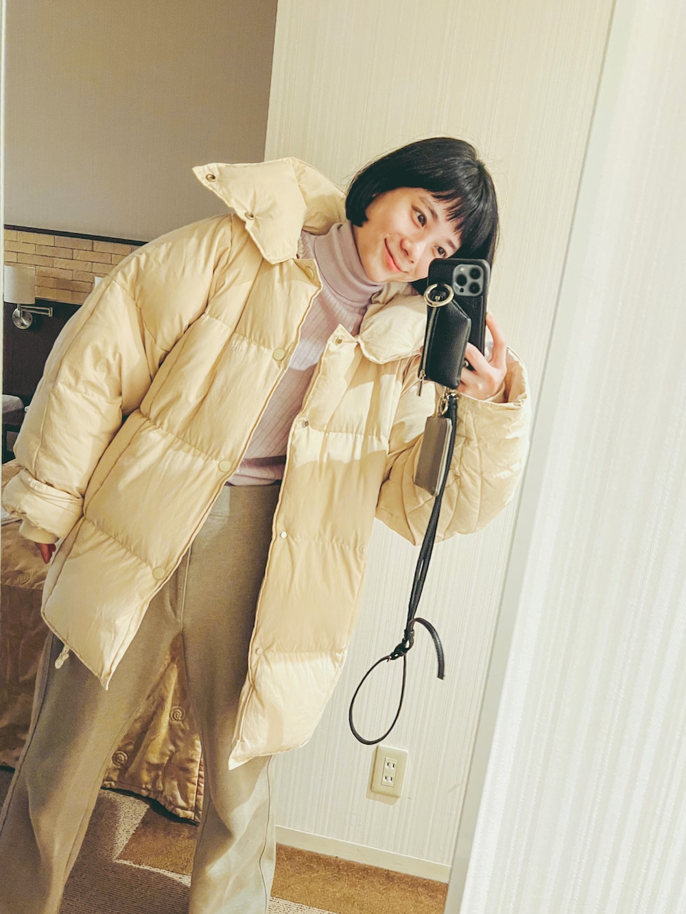 パープル系のニット/セーター、ベージュ系のカーディガン/ボレロ、ホワイト系のスニーカーを着用したレディースの冬コーディネートの3枚目の写真