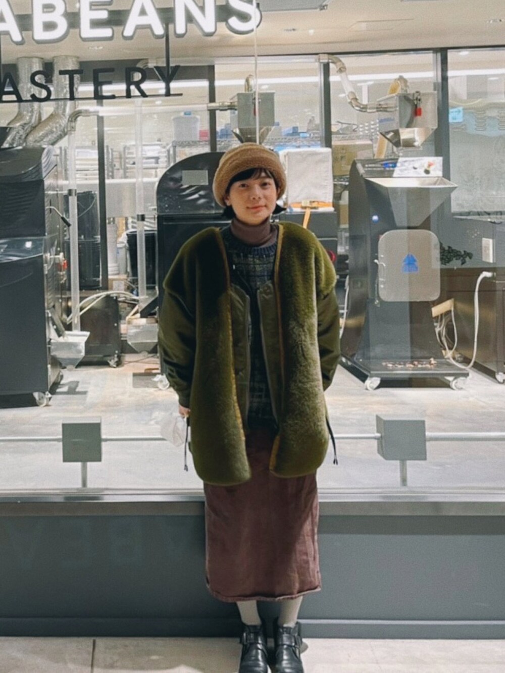 グリーン系のその他アウター、ブラウン系のニット/セーター、ブラウン系のスカートを着用したレディースの冬コーディネートの3枚目の写真