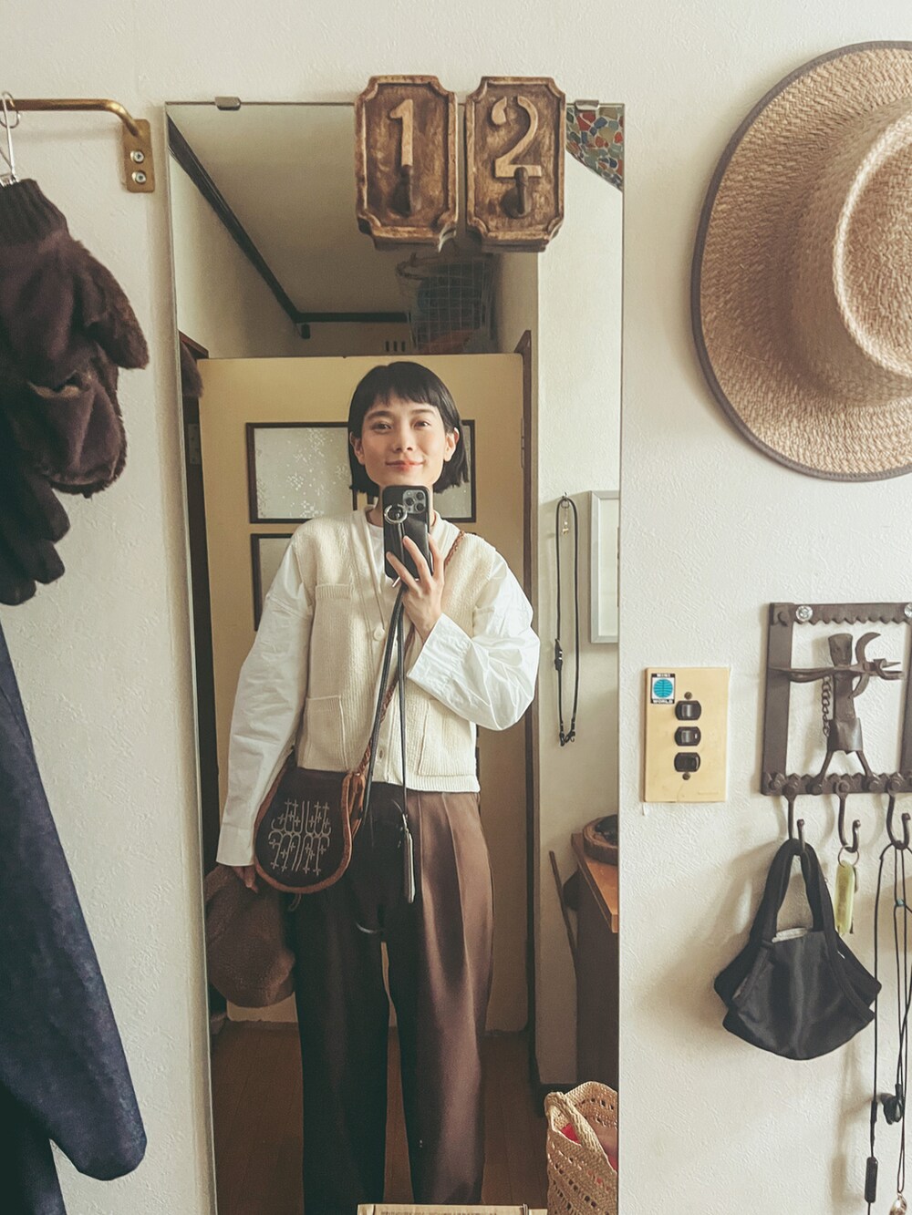 ブラウン系のその他パンツ、その他のベスト、ブラウン系のショルダーバッグを着用したレディースの春コーディネートの2枚目の写真