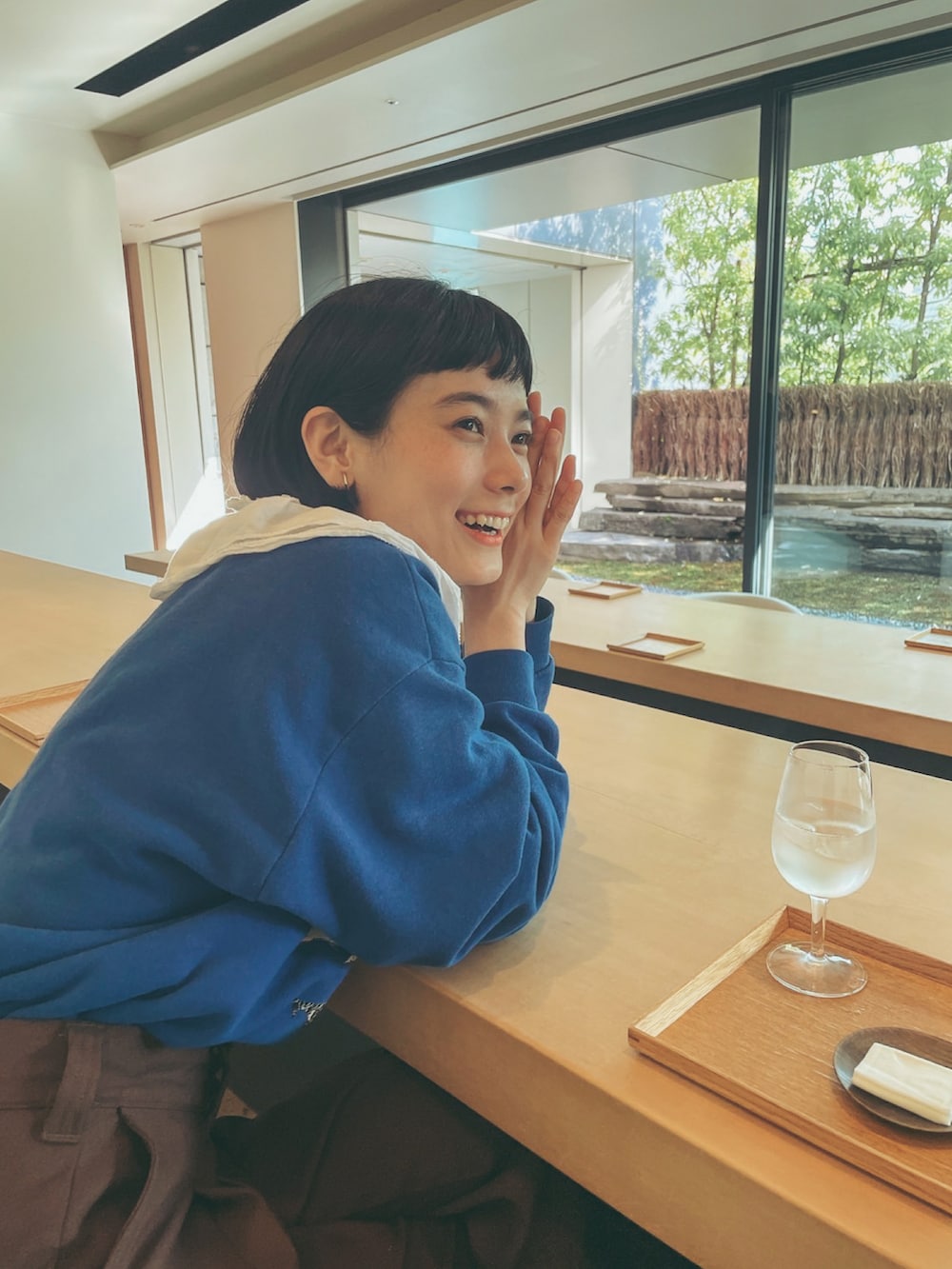 ブルー系のスウェット、ホワイト系のシャツ/ブラウス、ブラウン系のその他パンツを着用したレディースの夏コーディネートの3枚目の写真