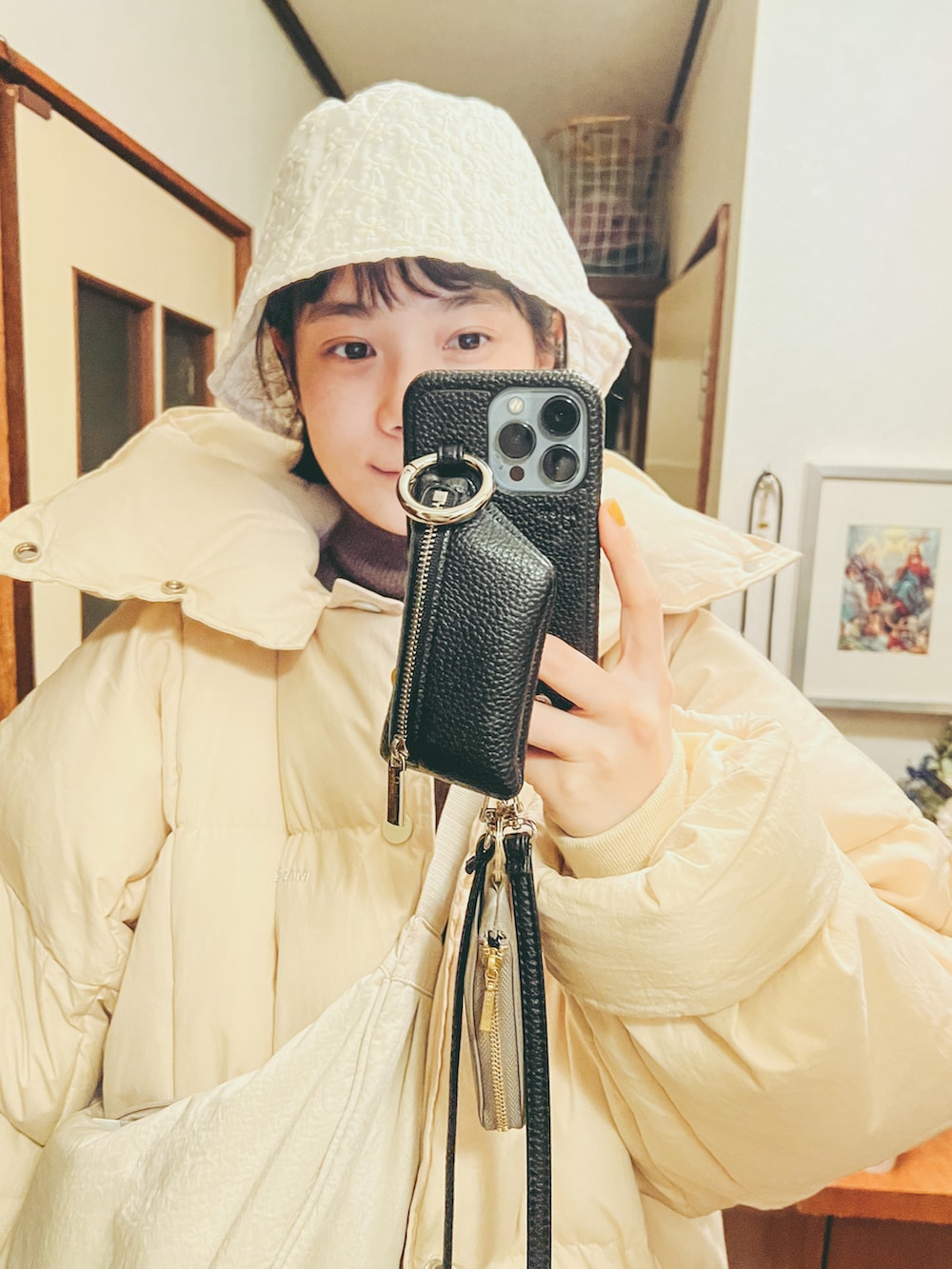 ホワイト系のダウンジャケット/コート、ブラウン系のニット/セーター、ホワイト系のボディバッグ/ウエストポーチを着用したレディースの冬コーディネートの4枚目の写真