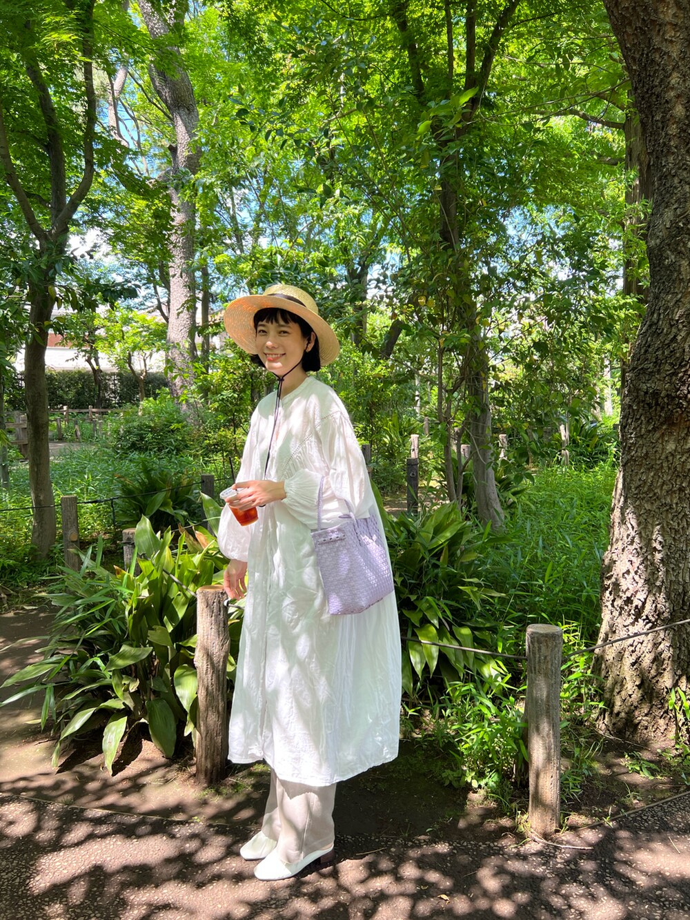 ホワイト系のワンピース、パープル系のかごバッグ、ベージュ系のその他パンツを着用したレディースの春コーディネートの3枚目の写真