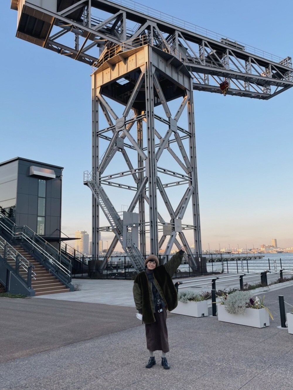 グリーン系のその他アウター、ブラウン系のニット/セーター、ブラウン系のスカートを着用したレディースの冬コーディネートの2枚目の写真