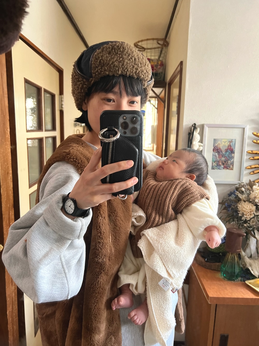 ブラウン系のベスト、ホワイト系のスウェットパンツ、ブラック系のデジタル腕時計を着用したレディースの春コーディネートの2枚目の写真