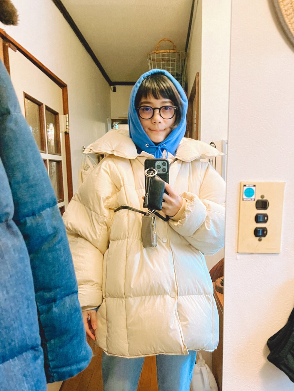 ホワイト系のダウンジャケット/コート、ブルー系のパーカー、ブルー系のデニムパンツを着用したレディースの冬コーディネートの2枚目の写真