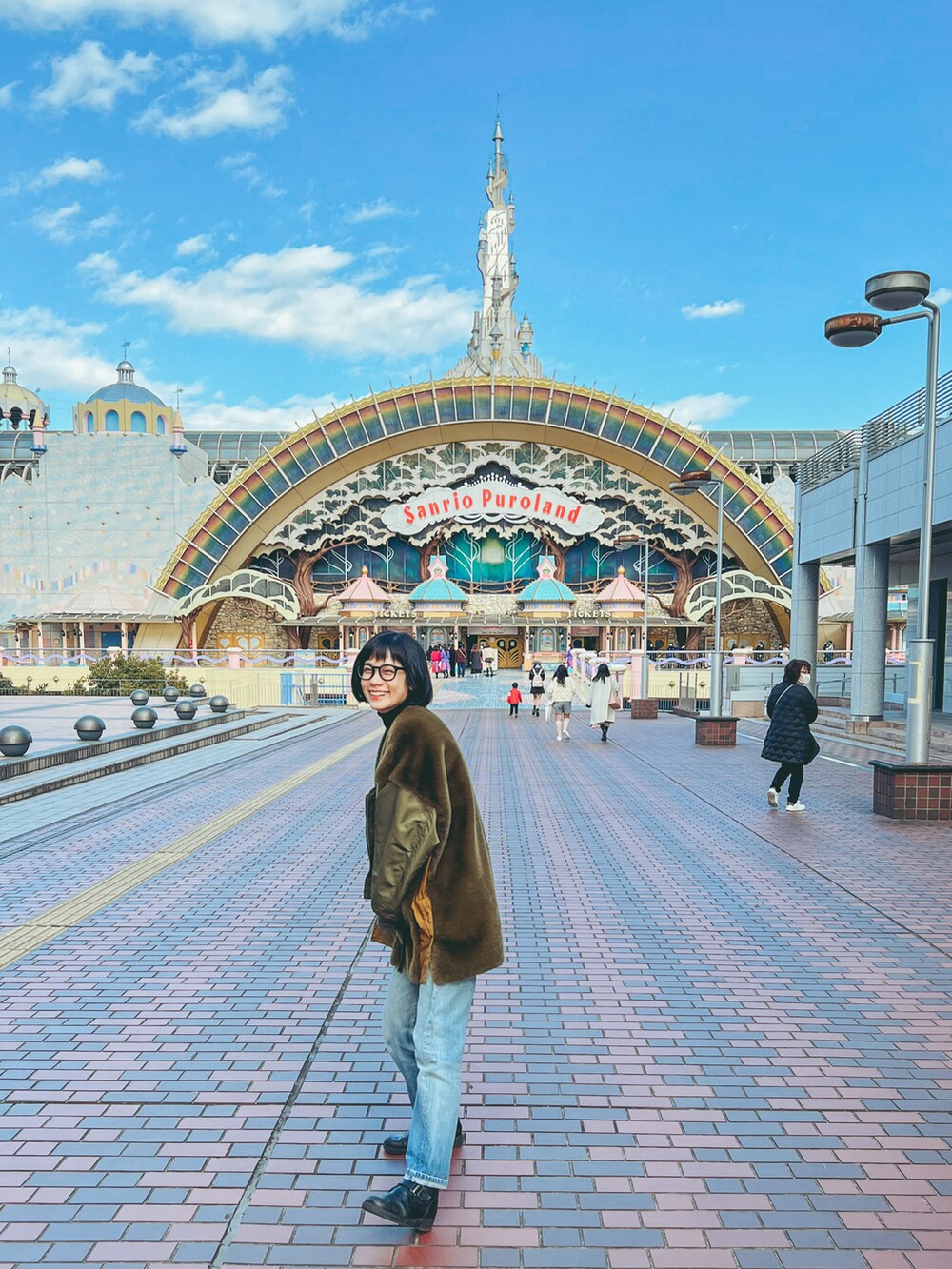 グリーン系のその他アウター、ブラック系のニット/セーター、ブルー系のデニムパンツを着用したレディースの冬コーディネートの2枚目の写真