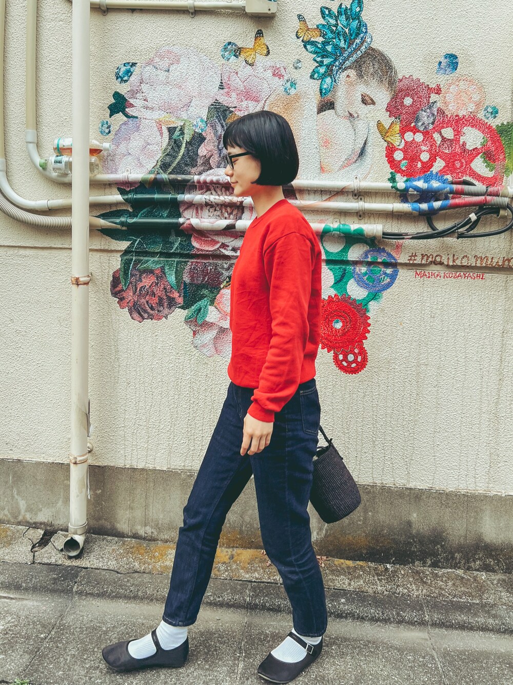 ブルー系のデニムパンツ、ブラック系のバレエシューズ、レッド系のスウェットを着用したレディースの春コーディネートの3枚目の写真