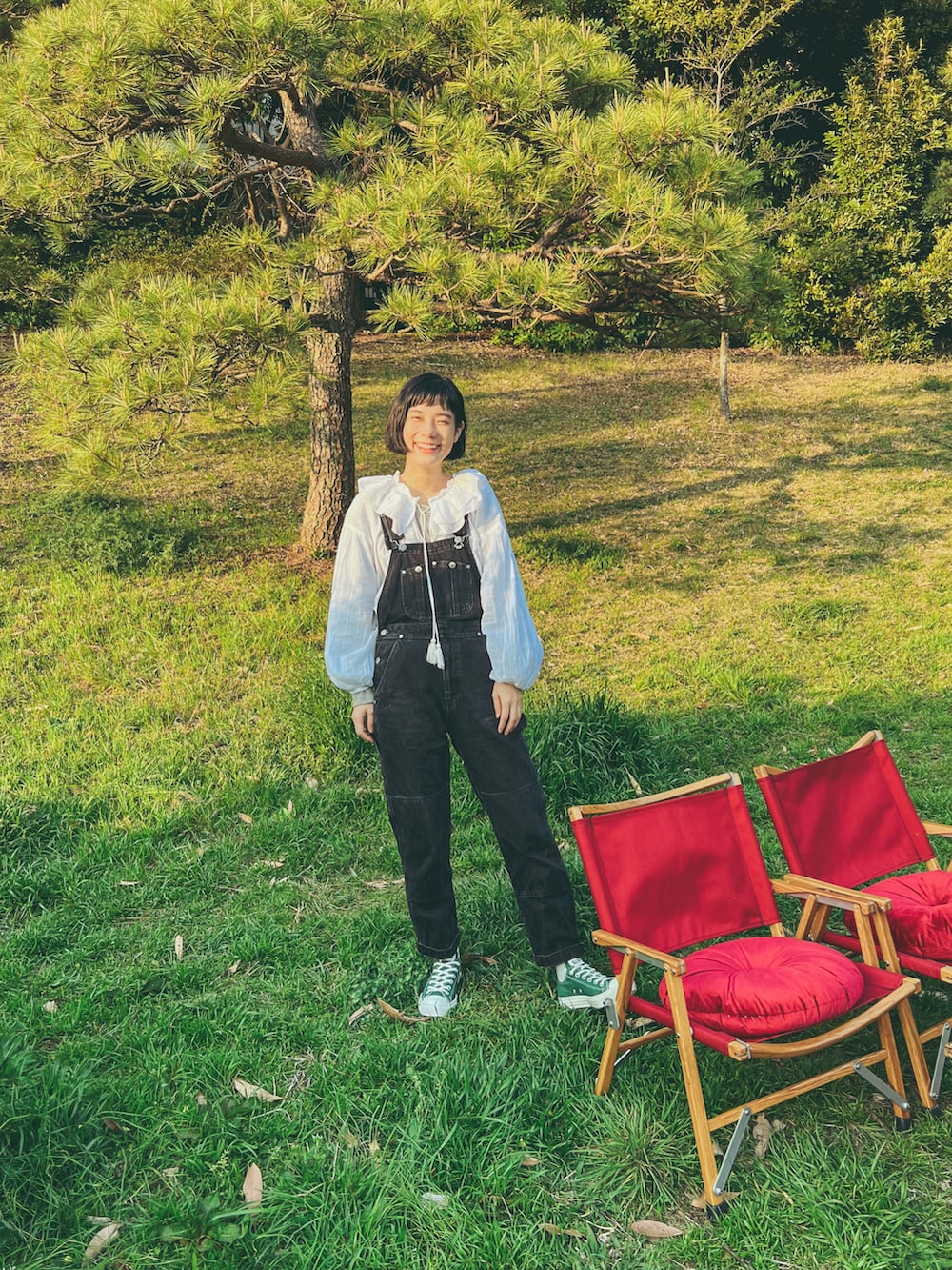 ホワイト系のシャツ/ブラウス、ブラック系のサロペット/オーバーオール、グレー系のTシャツ/カットソーを着用したレディースの春コーディネートの2枚目の写真