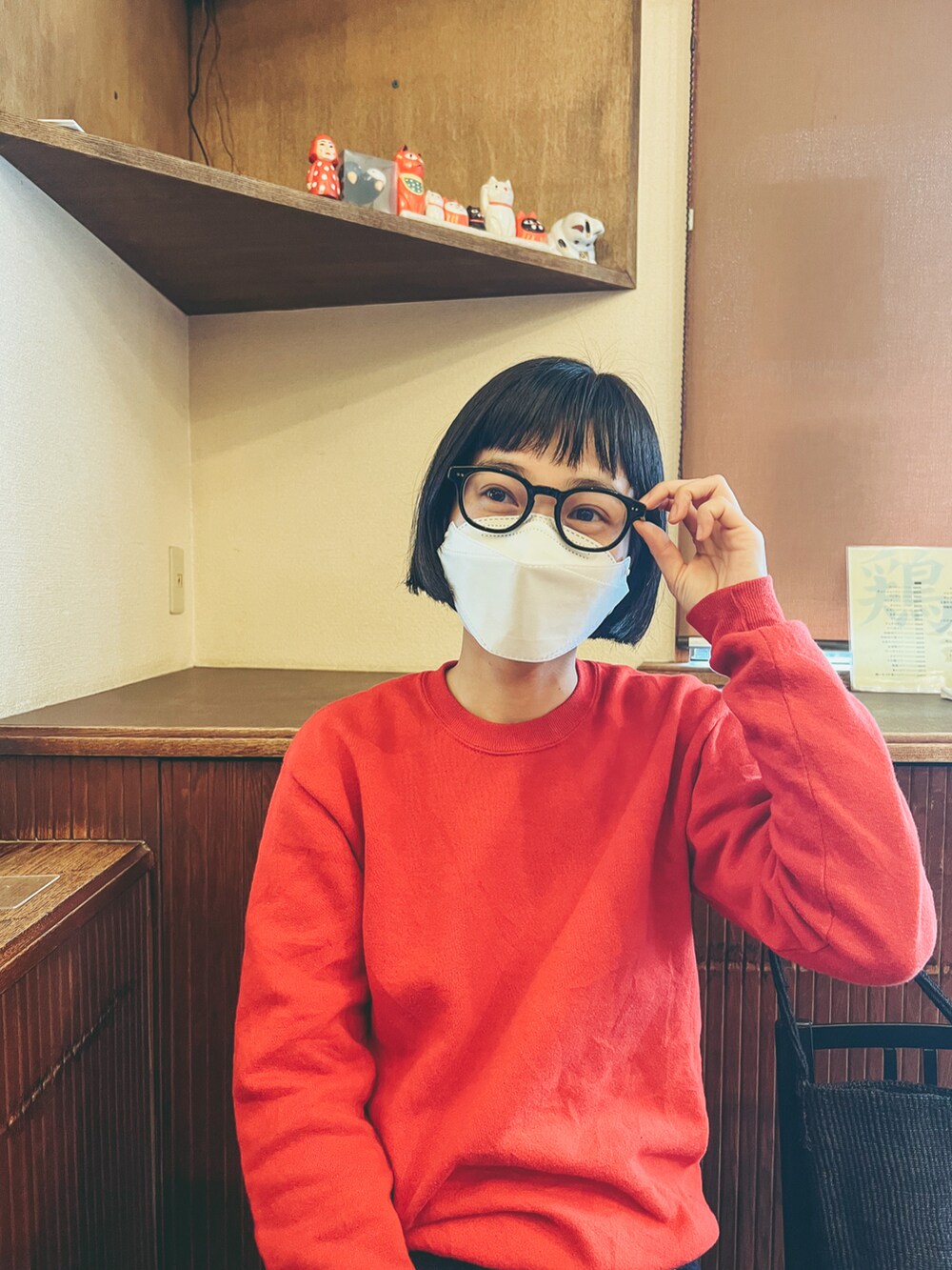 ブルー系のデニムパンツ、ブラック系のバレエシューズ、レッド系のスウェットを着用したレディースの春コーディネートの4枚目の写真