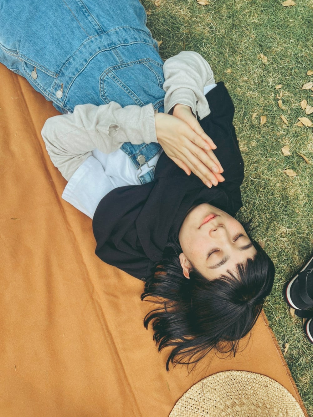 ブルー系のサロペット/オーバーオール、グリーン系のスニーカー、ベージュ系のハットを着用したレディースの夏コーディネートの3枚目の写真