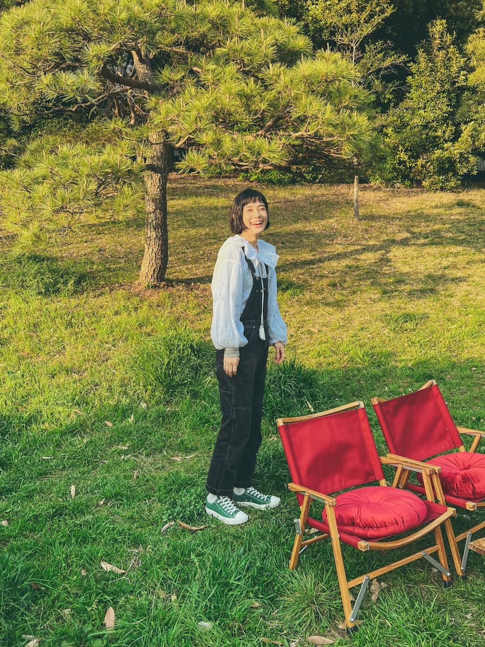 ホワイト系のシャツ/ブラウス、ブラック系のサロペット/オーバーオール、グレー系のTシャツ/カットソーを着用したレディースの春コーディネートの3枚目の写真