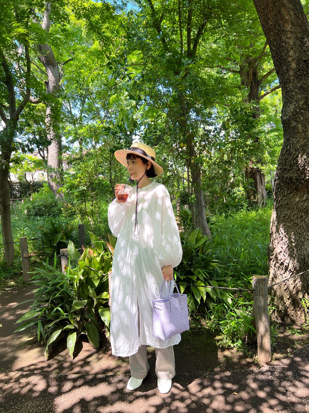 ホワイト系のワンピース、パープル系のかごバッグ、ベージュ系のその他パンツを着用したレディースの春コーディネートの2枚目の写真