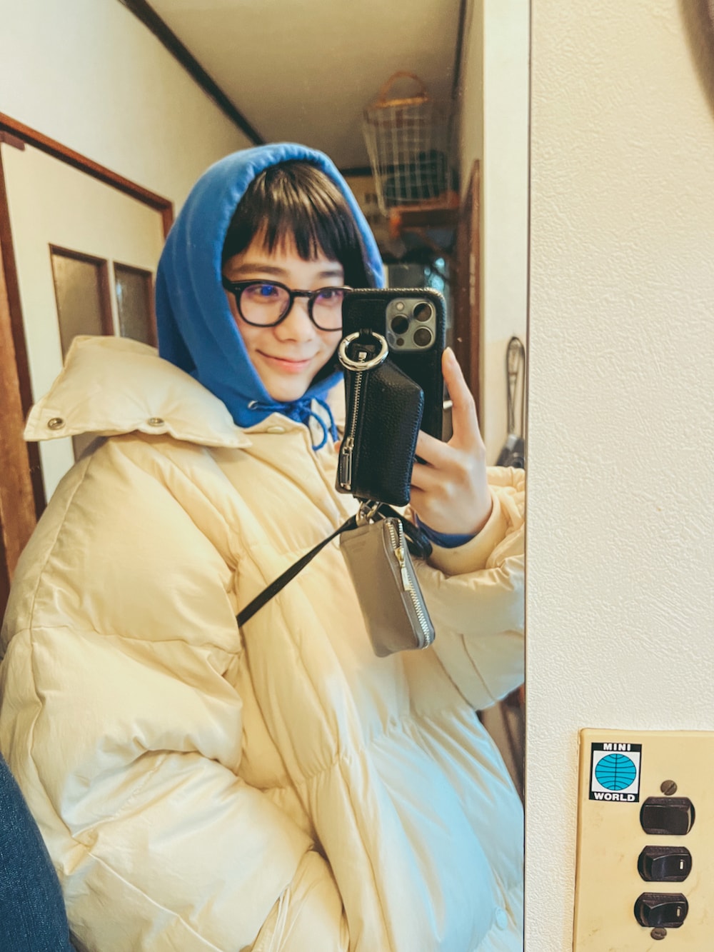 ホワイト系のダウンジャケット/コート、ブルー系のパーカー、ブルー系のデニムパンツを着用したレディースの冬コーディネートの3枚目の写真