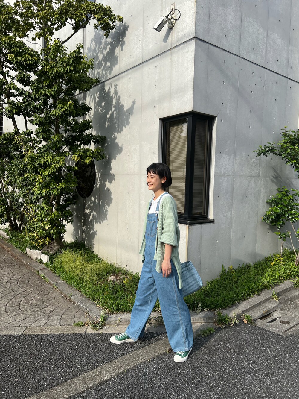 グリーン系のカーディガン/ボレロ、ブルー系のサロペット/オーバーオール、ブルー系のかごバッグを着用したレディースの春コーディネートの4枚目の写真