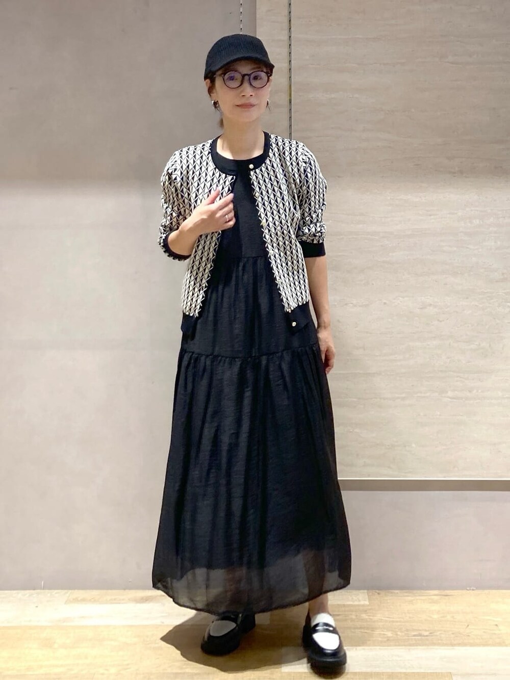 ブラック系のカーディガン/ボレロ、ブラック系のワンピース、ブラック系のパンプスを着用したレディースの秋コーディネートの3枚目の写真