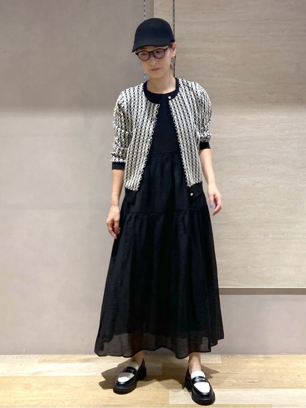 ブラック系のカーディガン/ボレロ、ブラック系のワンピース、ブラック系のパンプスを着用したレディースの秋コーディネートの2枚目の写真