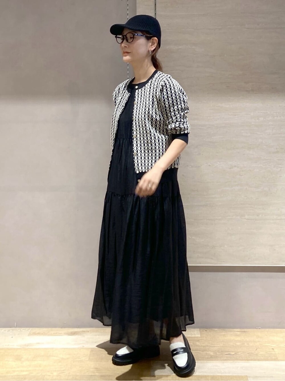 ブラック系のカーディガン/ボレロ、ブラック系のワンピース、ブラック系のパンプスを着用したレディースの秋コーディネートの6枚目の写真