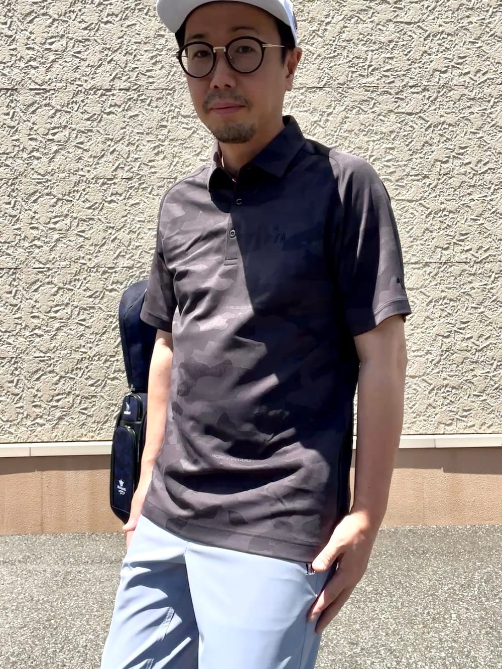 グレー系のポロシャツ、ブルー系のその他パンツ、ホワイト系のキャップを着用したメンズの夏コーディネートの6枚目の写真