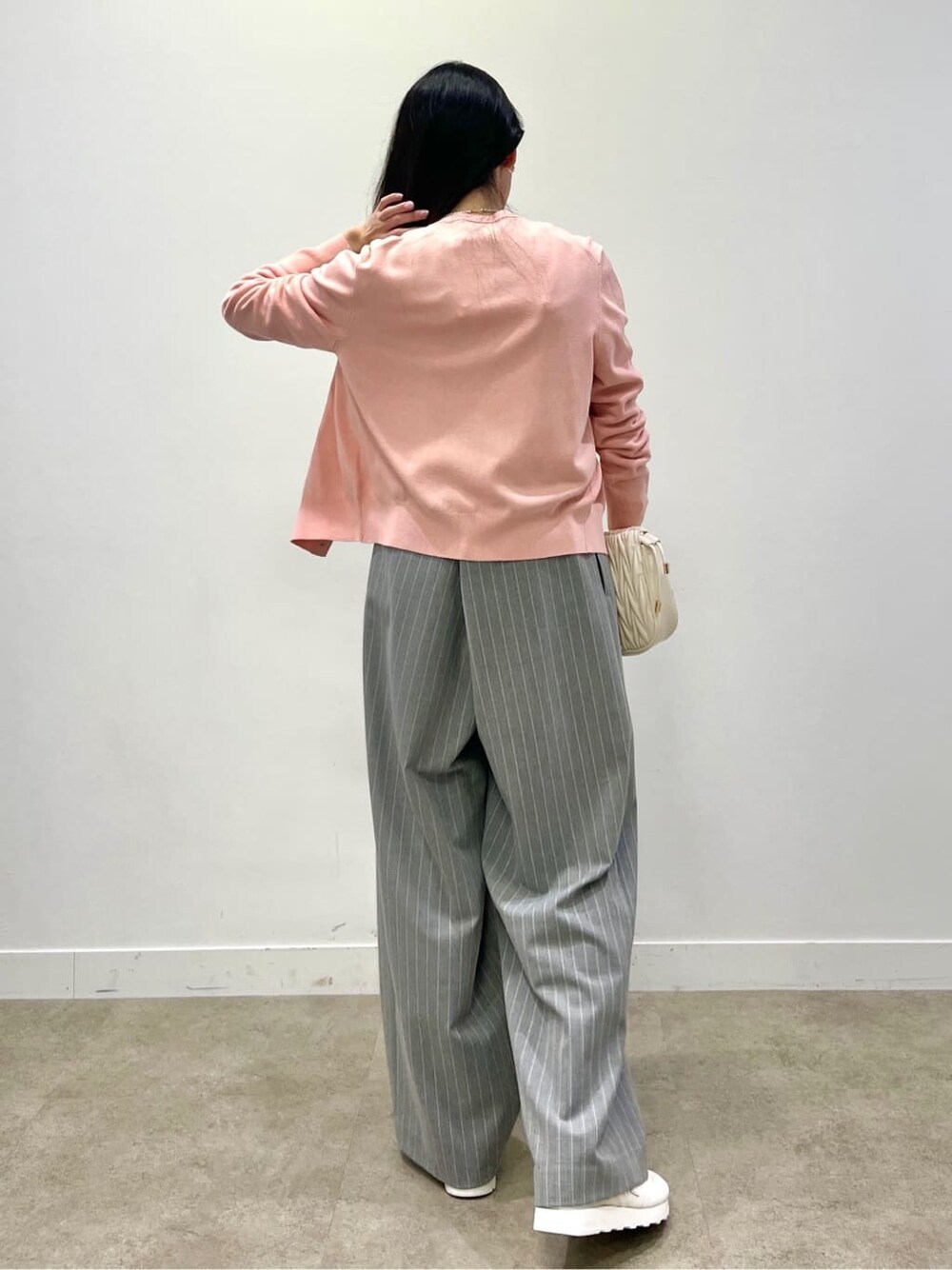 オレンジ系のニット/セーター、オレンジ系のカーディガン/ボレロを着用したレディースの冬コーディネートの6枚目の写真