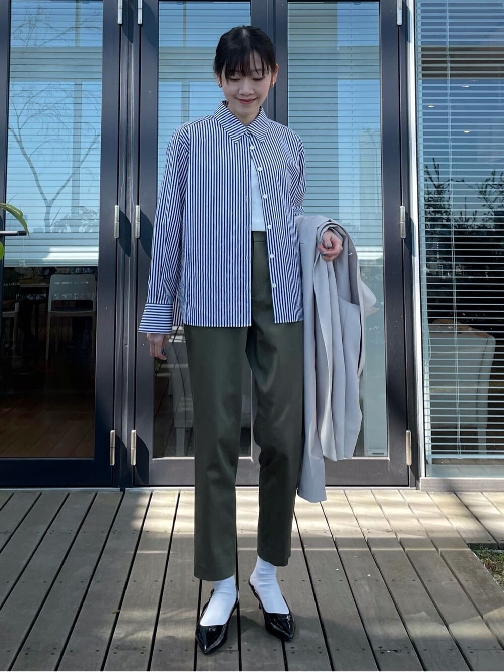 ブルー系のシャツ/ブラウスを着用したレディースの春コーディネートの2枚目の写真