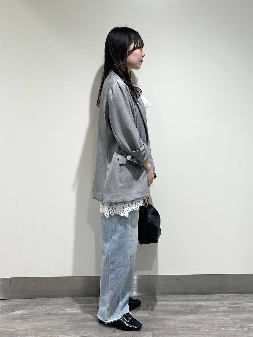 ブルー系のデニムパンツ、ホワイト系のキャミソール、ブラック系のノーカラージャケットを着用したレディースの春コーディネートの2枚目の写真