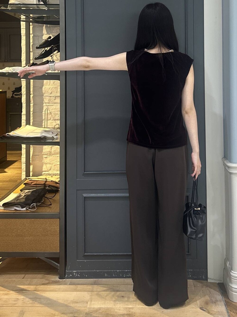 ブラック系のショルダーバッグ、ブラウン系のスラックス、ブラウン系のTシャツ/カットソーを着用したレディースの夏コーディネートの3枚目の写真