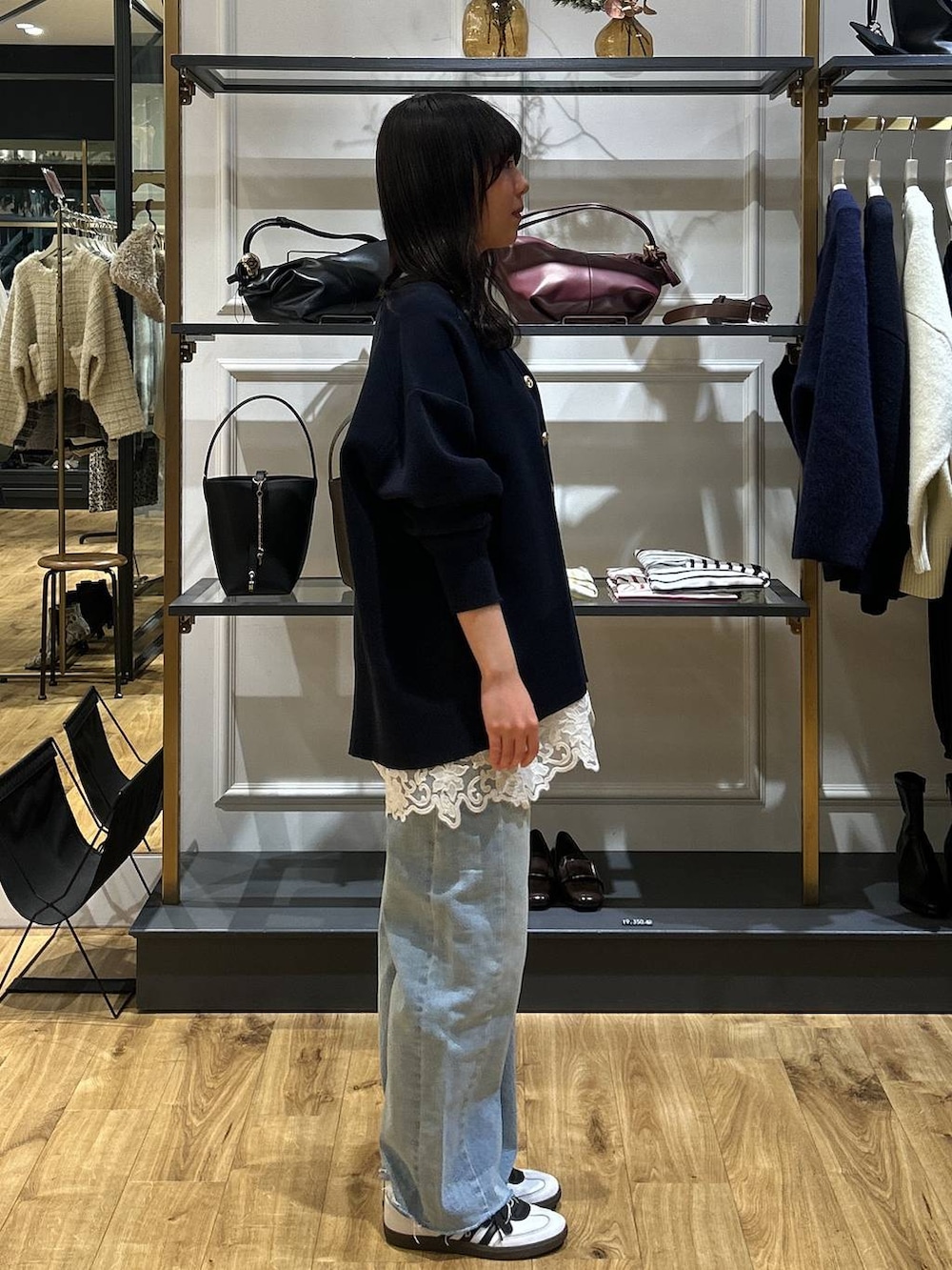 ブルー系のカーディガン/ボレロ、ブルー系のデニムパンツ、ホワイト系のキャミソールを着用したレディースの冬コーディネートの2枚目の写真