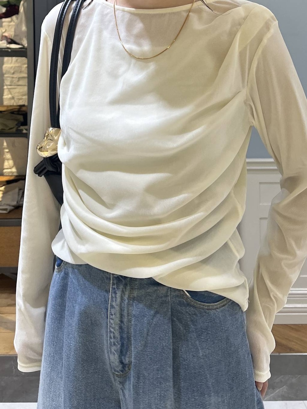 ブラック系のショルダーバッグ、ブルー系のデニムパンツ、ホワイト系のTシャツ/カットソーを着用したレディースの秋コーディネートの5枚目の写真