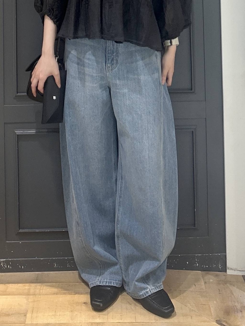 ブラック系のシャツ/ブラウス、ブルー系のデニムパンツ、ブラック系のショルダーバッグを着用したレディースの夏コーディネートの2枚目の写真