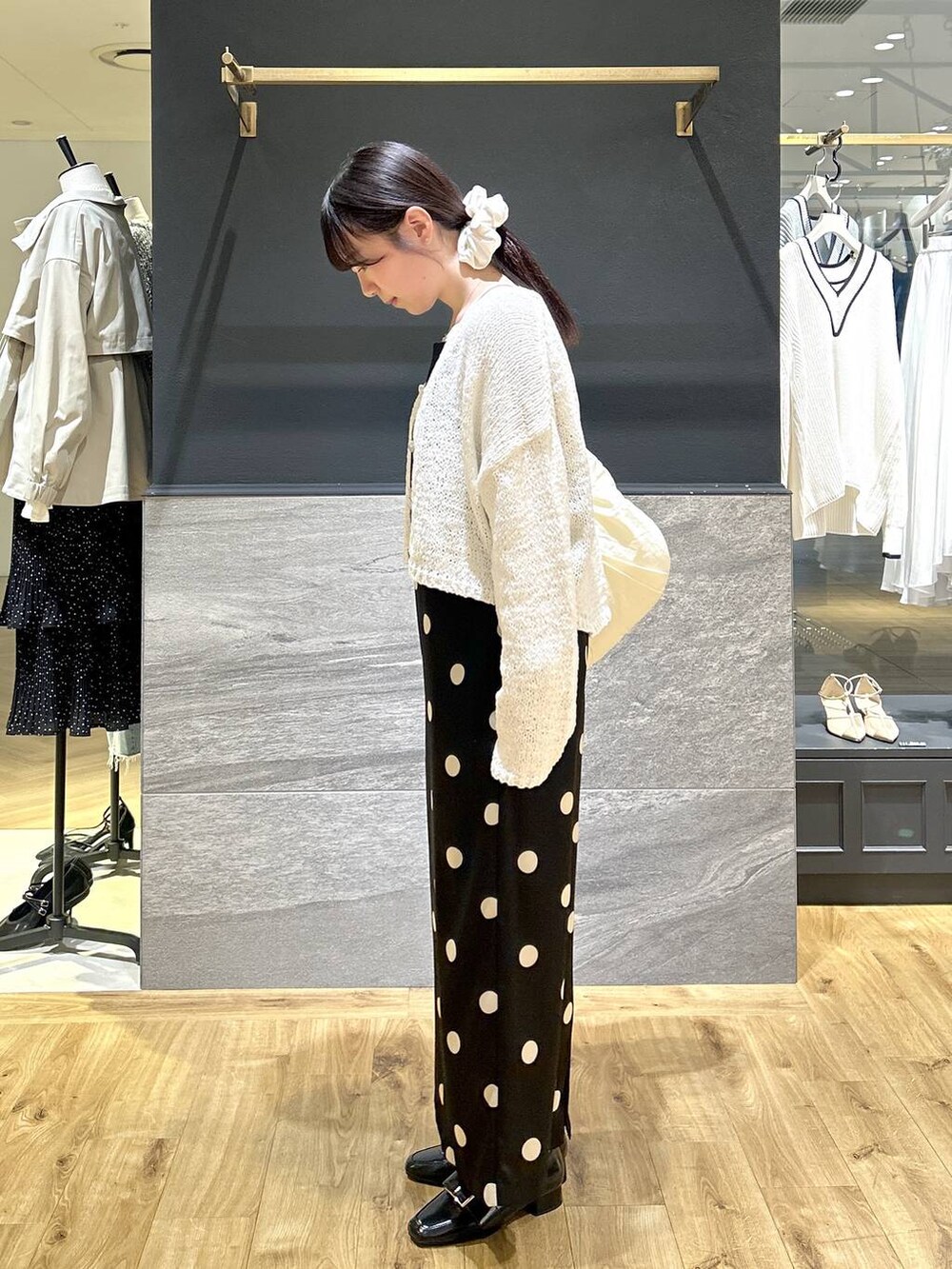 ブラック系のワンピース、ホワイト系のカーディガン/ボレロを着用したレディースの春コーディネートの2枚目の写真